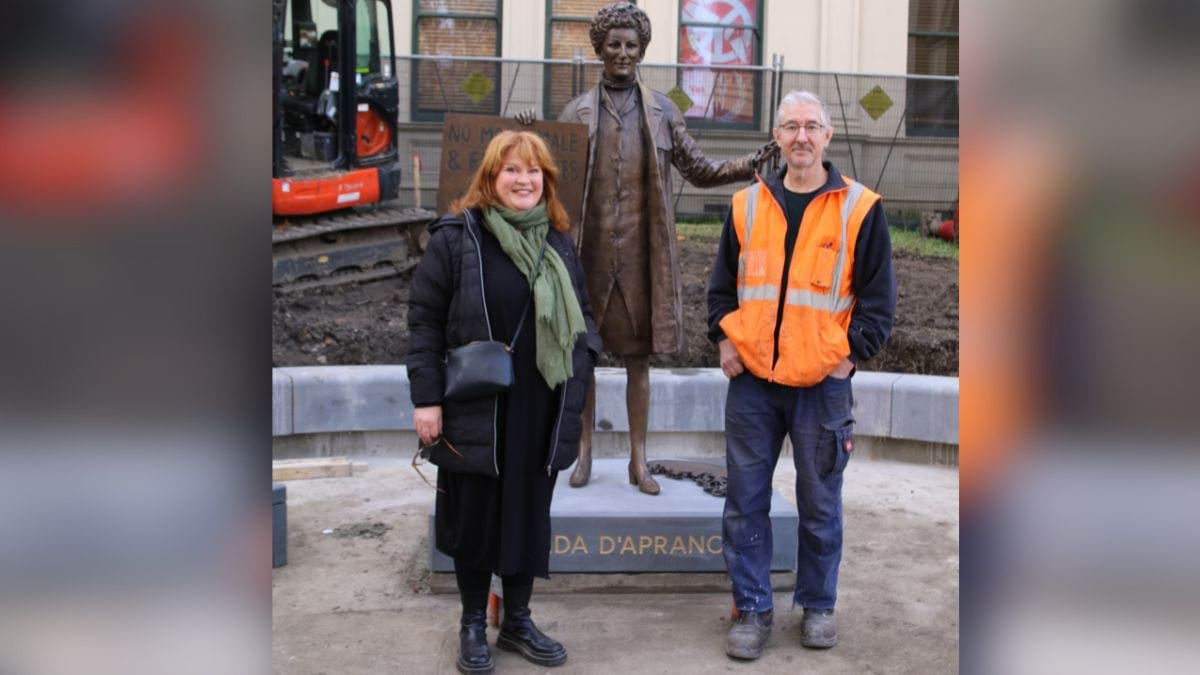 Sculptor Jennifer Mann and Cameron from the foundry with the bronze statue of Zelda D’Aprano in front of the Victorian Trades Hall.