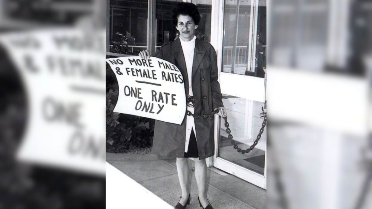 Photograph of Zelda D’Aprano chained to a courthouse. She is holding a sign that says