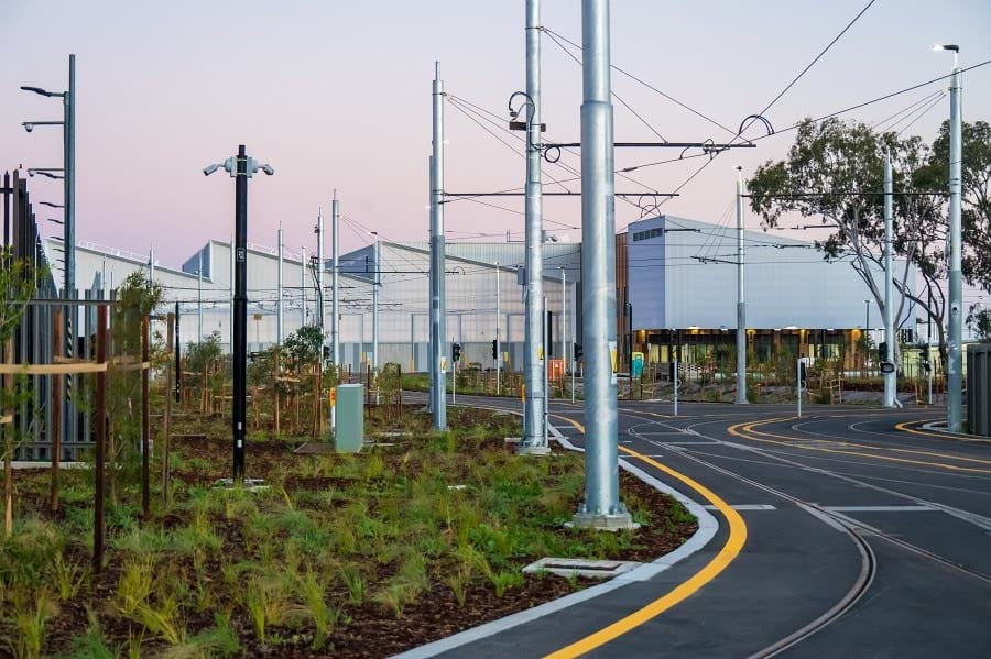 A Tram depot showing tracks, saw-tooth roof, buildings, and landscaping